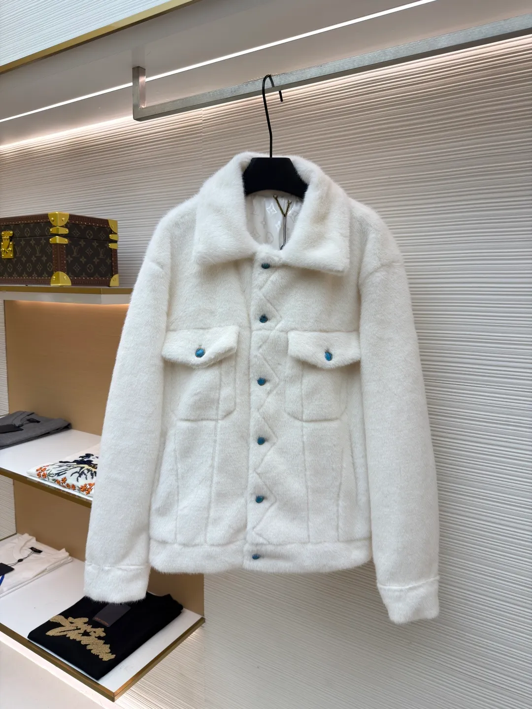LOUIS VUITTON Turquoise Mink Jacket ●Original version: Purchased and developed at 147799 ●Item number: 1681421-C30 ●Fabric: mink fur fabric ●Technology: embroidery production ●Color: white ●Version: Fitted version ●Weight: about 1065 grams ●Size: 46-48-50-52 ●Description: This jacket is made of high-end imitation mink velvet fabric, which is soft and fluffy to the touch and has excellent warmth retention. The lapel design adopts three-dimensional tailoring + precision sewing technology, and the collar shape is crisp and naturally connected with the body. The placket button is a custom-made blue-green metal button, which creates a visual contrast with the white fabric. It is sewn in precise position and opens and closes smoothly. The large pockets on both sides use three-dimensional bag-shaped technology, and the bag mouth echoes the buttons, combining practicality and design. The inner lining is made of the brand's classic pattern printed fabric, which is combined with the outer layer of plush fabric through laminating sewing technology to create a strong sense of layering. The overall cut is a loose-shouldered version, and the multi-piece structure is spliced ​​to create a casual and trendy wearing effect while ensuring comfort and freedom during movement. It is a fashionable item that combines luxurious plush texture with exquisite craftsmanship. The overall wiring is straight and delicate, the fabric is comfortable and soft, and the color is consistent without color difference. It can be matched with the same style to create a fashionable look and control various occasions. Customized accessories, complete with three standards, same style for men and women!